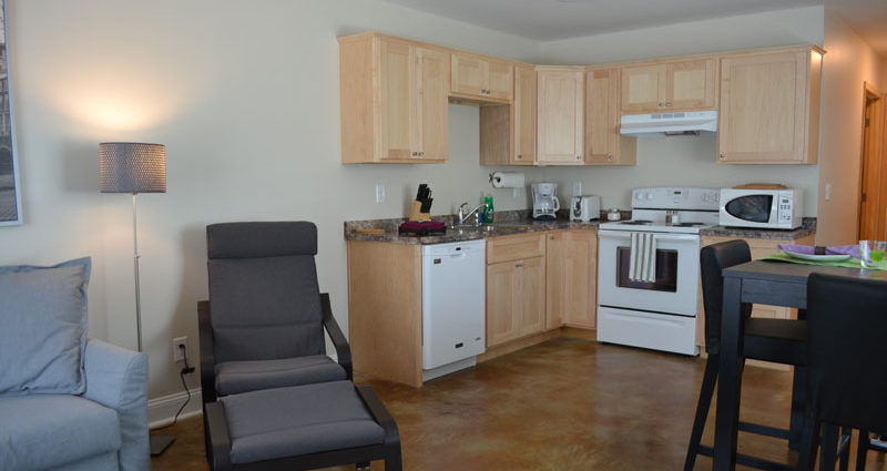 A kitchen with a chair and stove in it