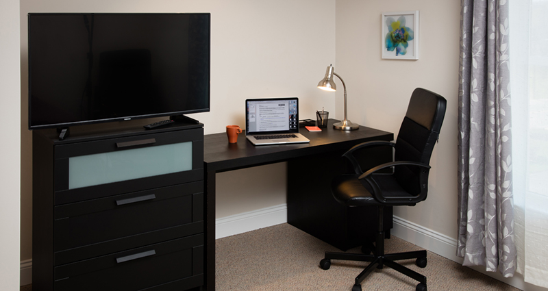 A desk with a laptop and monitor on it.