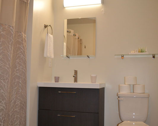 A bathroom with a sink, mirror and toilet.