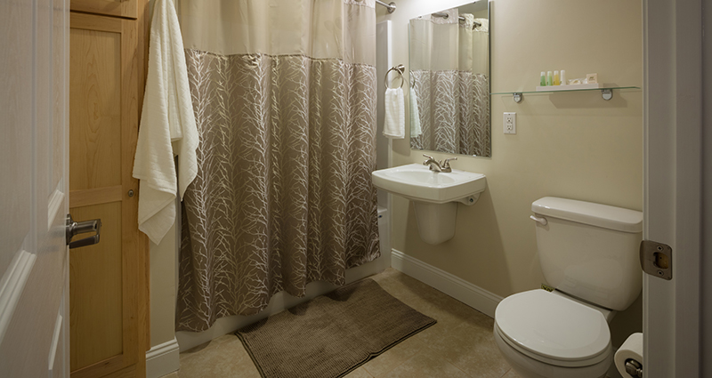 A bathroom with a sink, toilet and mirror.