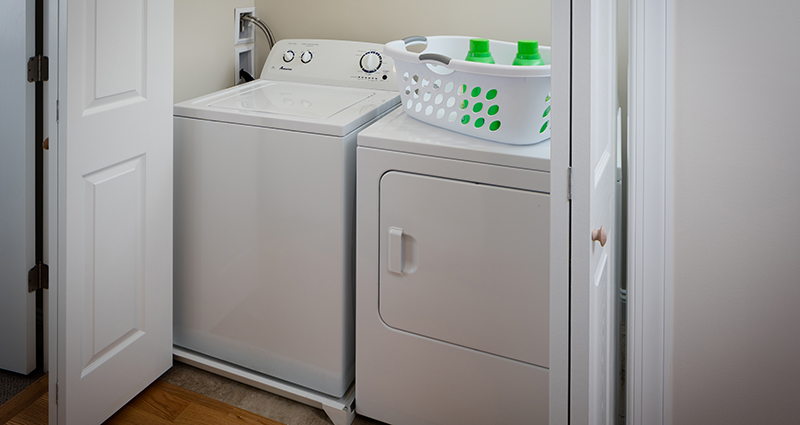 A washer and dryer in the corner of a room.