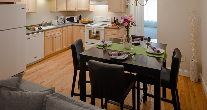 A kitchen with wooden floors and white cabinets.