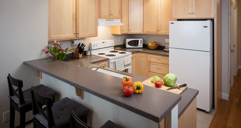 A kitchen with wooden cabinets and white appliances.