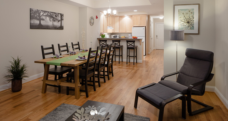 A dining room table and chairs in the middle of a kitchen.