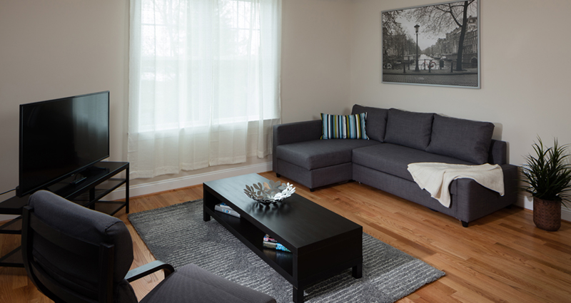 A living room with a couch, chair and coffee table.